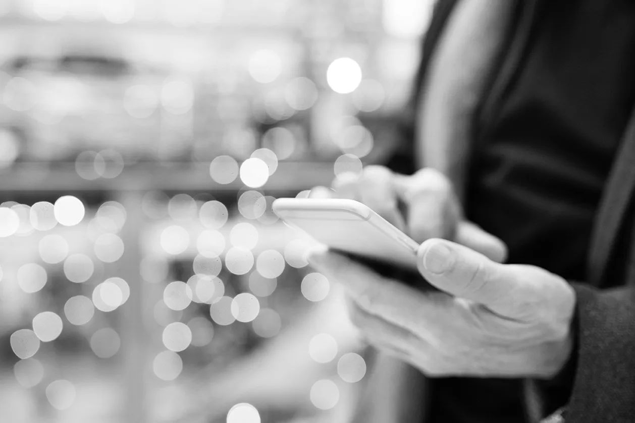 Black and white image of an older generation gentleman working on the mobile app